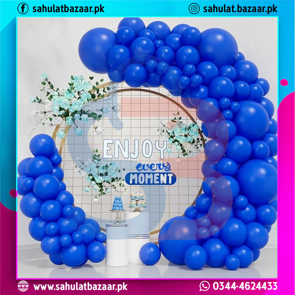Blue balloon arch with 'Enjoy every moment' sign in a decorated room.