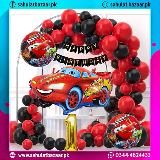 Birthday balloon arch with red, black, and gold balloons featuring a car design and 'Happy Birthday' banner.