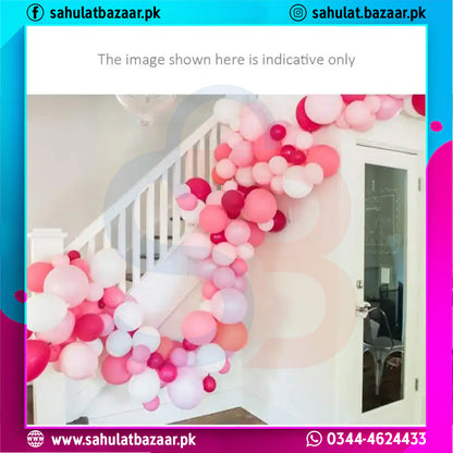 Balloon arch with pink, red, and white balloons in a room.