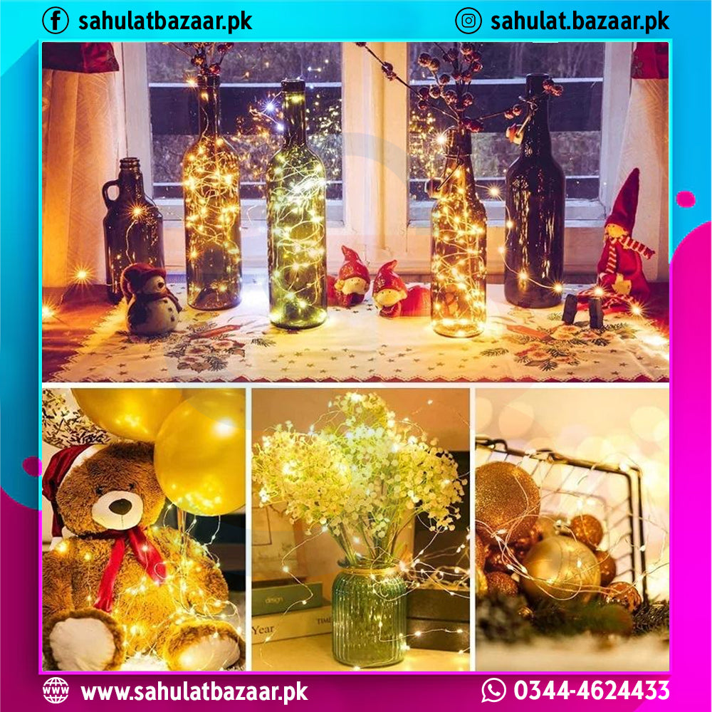 Decorative setup with bottles, teddy bear, and flowers using string lights, featuring 'sahulatbazaar.pk' branding.