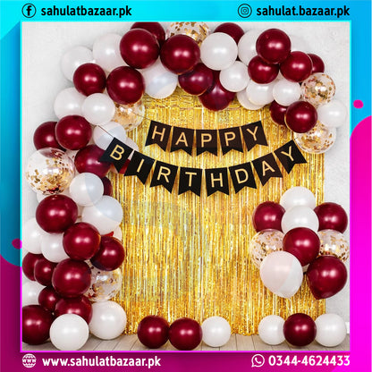 Birthday balloon arch with 'Happy Birthday' banner against a gold curtain, featuring red, white, and gold balloons.