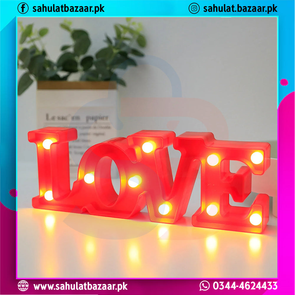 Red 'LOVE' light-up sign on a white surface with a blurred background