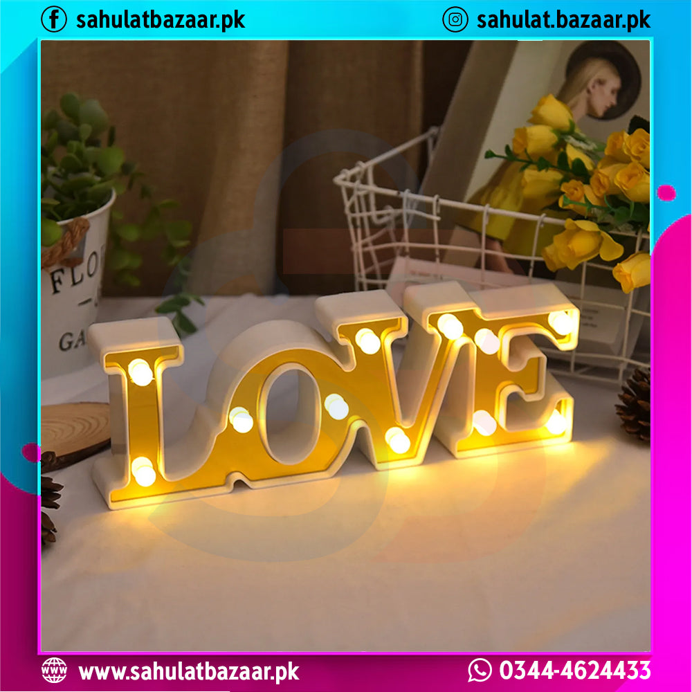 Decorative LED sign spelling 'LOVE' on a table with a blurred background